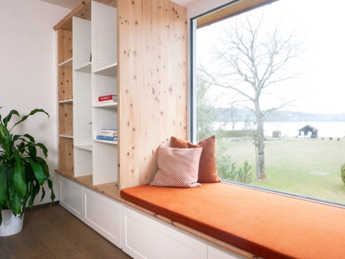 Maßgefertigte Liegebank am Fenster mit angeschlossenem Bücherregal